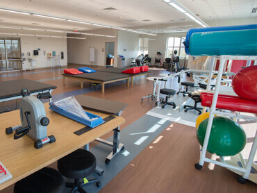 Exercise equipment and therapy beds in a therapy gym.