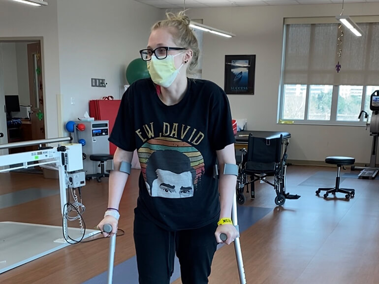 Callie improves her walking using forearm crutches as part of her therapy.