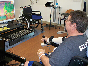 Patient using Armeo Spring robotic training tool to increase arm coordination.