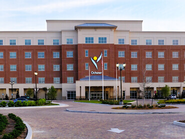 Exterior of hospital and driveway on clear day.