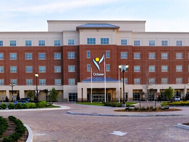 Exterior of hospital and driveway on clear day.