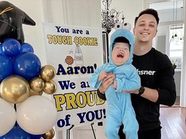 Aaron Beckner holds his toddler son at a celebration party for his recovery.